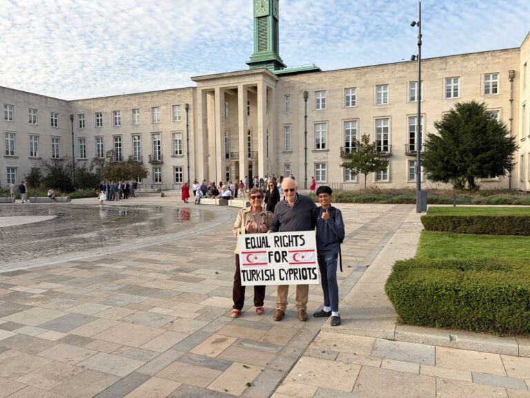 Two Embargoed! campaigners and a schoolboy give a thumbs-up behind an "Equal rights for Turkish Cypriots" banner in Fellowship Square, outside Waltham Forest Town Hall