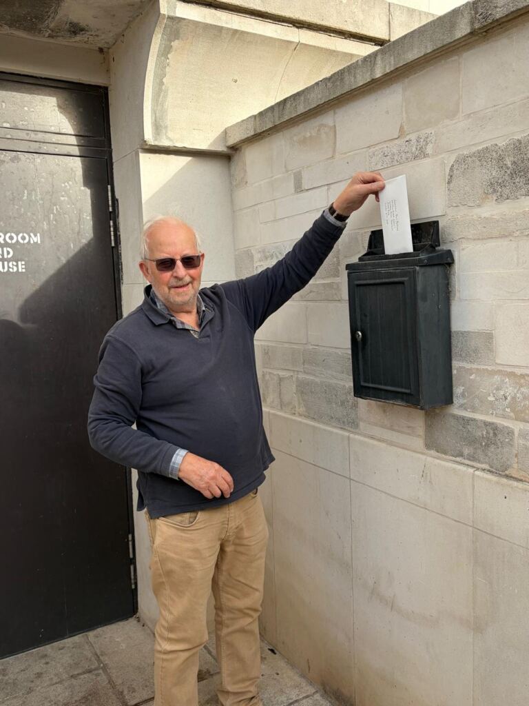 An Embargoed! campaigner posts the letter for the council leader into the letterbox at Waltham Forest Town Hall